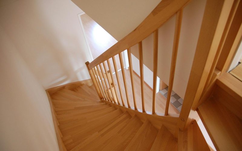 Wooden staircase with warm tones inside a minimalist home interior.