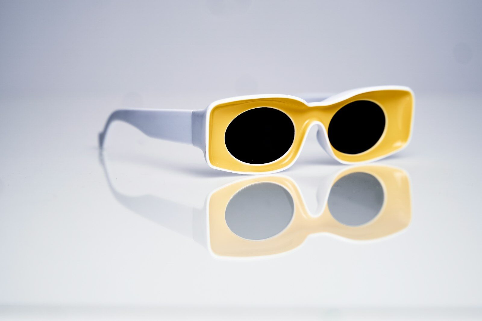 a pair of yellow sunglasses sitting on top of a table